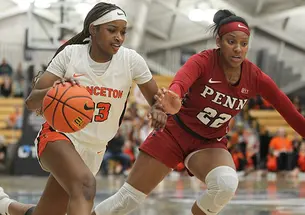 Princeton player dribbles with right hand, Penn defender on her left