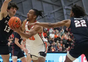 Princeton player Tosan Evbuomwan scoops left-handed shot between two defenders