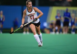 Field hockey player Beth Yeager '26 running and holding hockey stick