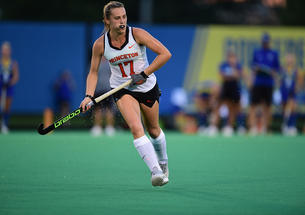 Field hockey player Beth Yeager '26 running and holding hockey stick