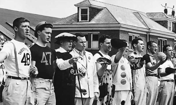Students in a variety of costumes stand shoulder-to-shoulder and sing at the Princeton-Yale baseball game, Reunions, 1949.