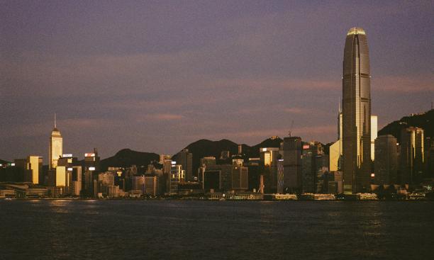 A Hong Kong city skyline photographed at dusk, the sky turning purple.