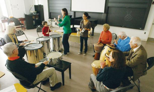 As part of Alumni Day activities, alumni and family members take part in a drum circle led by Frances Cornelius ’10, standing left, and Janet Kim ’10, members of Princeton’s Modern Improvisational Music Appreciation group.