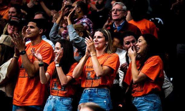 Orange T-shirt-clad fans cheer in the bleachers