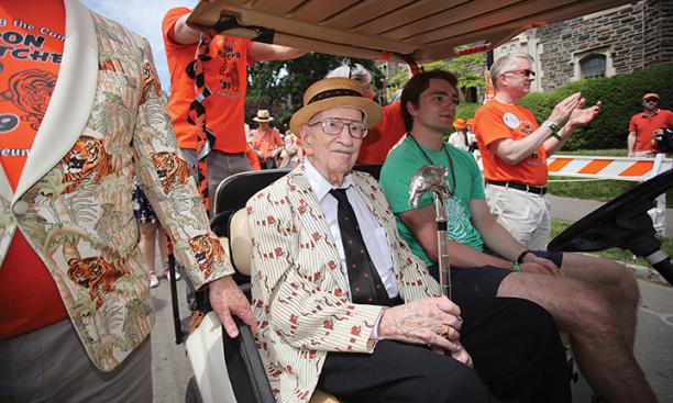 Don Fletcher ’39 *51 rides in a golf cart with the Class of 1923 Cane.
