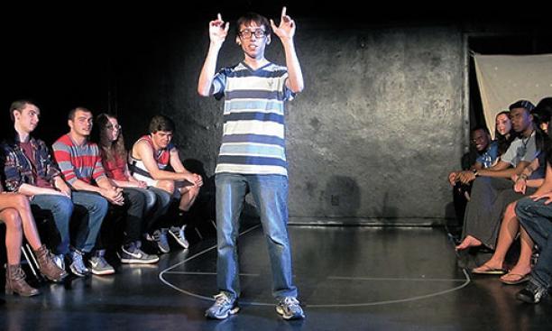 Patrick Roche ’14 performs on campus in 2013 as Ellipses Slam Team members look on.
