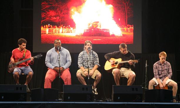 Football stars Caraun Reid '13 and Roman Wilson '14, second and third from left, respectively, led a rendition of "Ain't No Mountain High Enough," with an image of the Big Three bonfire in the background.
