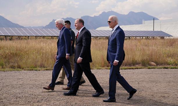 Jared Polis ’96, center, walks with President Joe Biden 