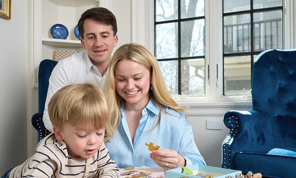 Brittany Sanders Robb ’13 at home with her husband, Andrew, and their son.