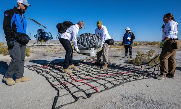NASA recovery team members prepare the space return capsule