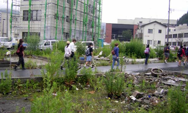 Students walk along a street marked by empty lots and buildings being repaired in Kamaishi, where 20 percent of the city center was inundated by the tsunami.