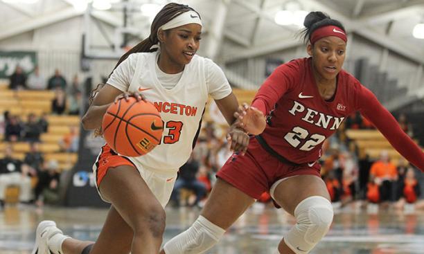 Princeton player dribbles with right hand, Penn defender on her left