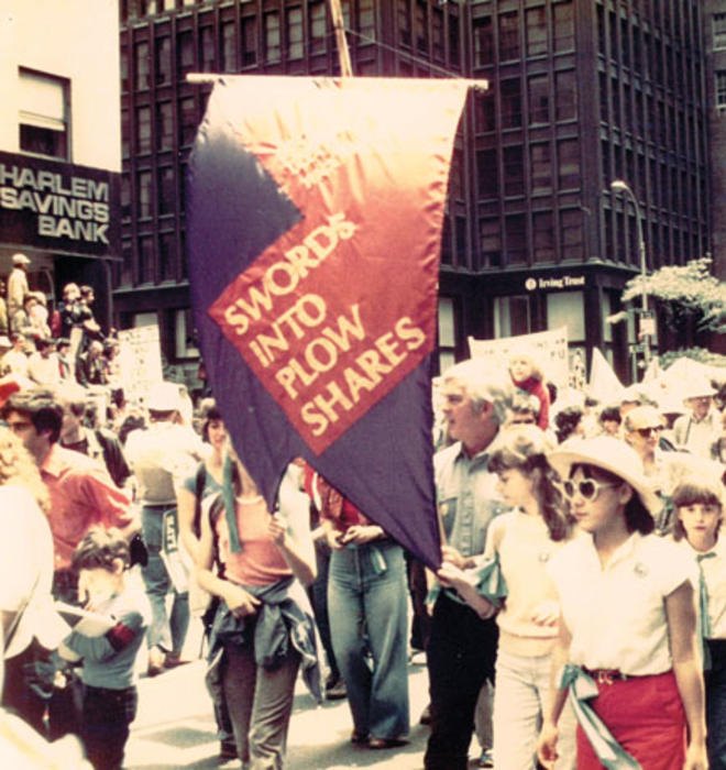 Dorman carries the banner in a 1982 march for a nuclear freeze. His three daughters are pictured beside him.