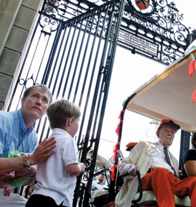 Riding in his golf cart at the P-rade in 2011, Warnock passes PAW writer W. Barksdale Maynard ’88 and his son, Alexander. 