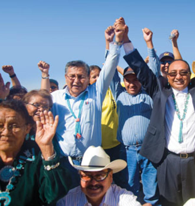 Rex Lee Jim ’86, center, joins hands with Navajo Nation presidential candidate Ben Shelly at a campaign stop in September at the Southwest Navajo Fair in Dilkon, Ariz.