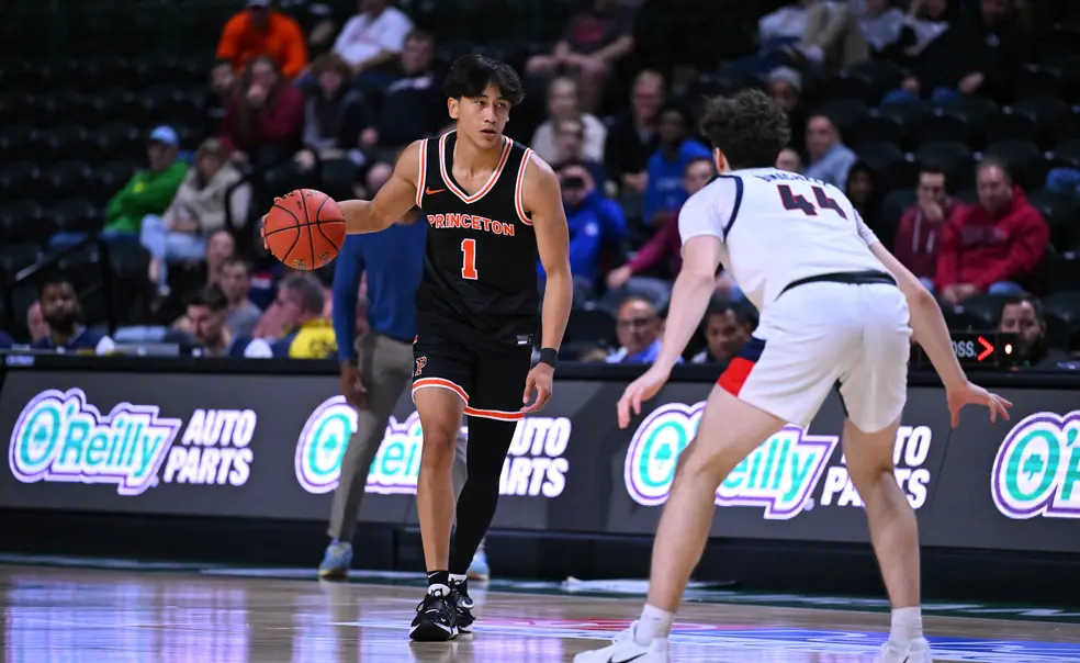 24_Xaivian_Lee_Action2024-11-08PrincetonMBBvDuquesne_2341.JPG A basketball player wearing a Princeton jersey with a #1 on it, dribbles while facing off a defender.