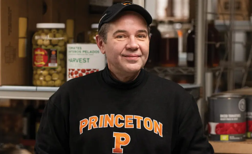 RG_Be Our Gest Damon Schunk.jpg Damon Schunk, a senior storekeeper in Campus Dining, standing in a large food pantry