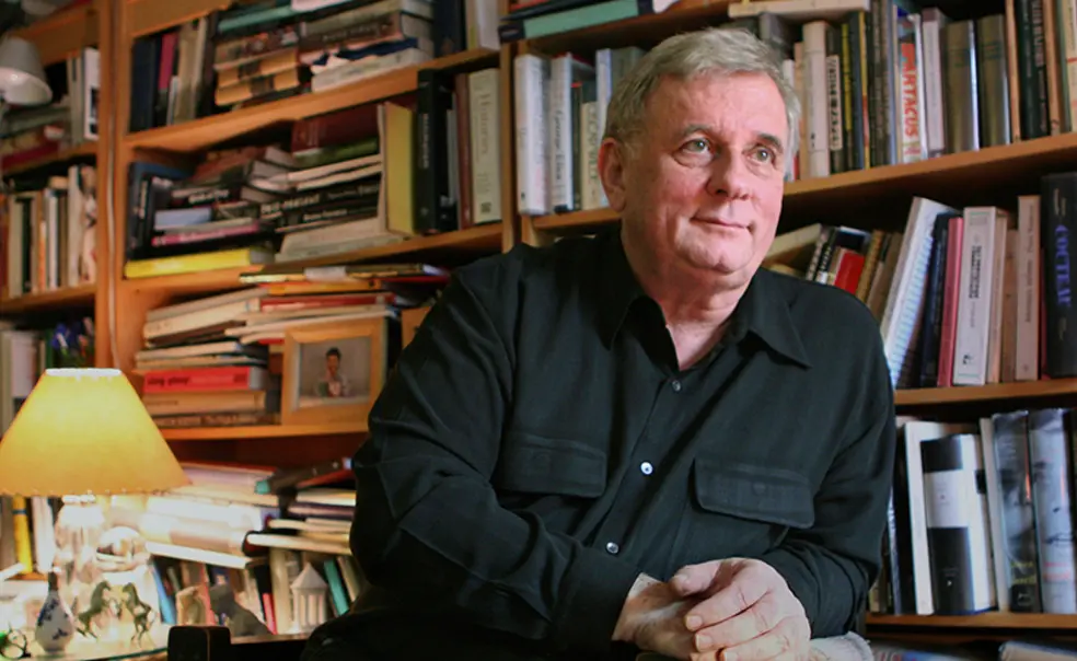 EdmundWhite_AP_2006.jpg Edmund White in front of a bookcase jammed with books.