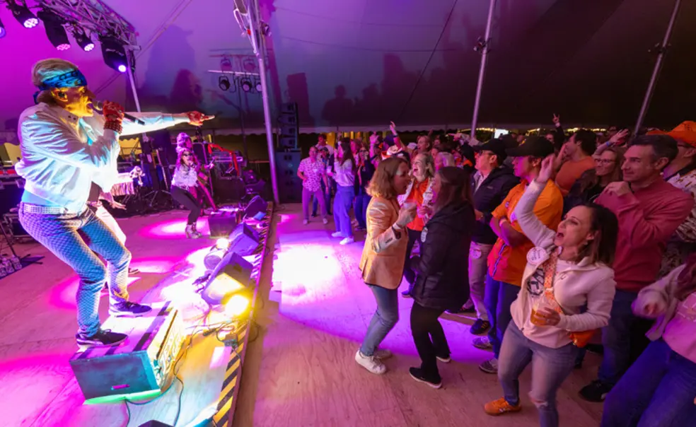 REUNIONS_Class of 1995 Rideshare.jpg A band playing at the Class of 1995 tent during Reunions with people dancing