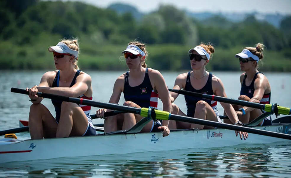 D5A_1706.jpg Four rowers at rest in a rowing shell on the water. Claire Collins is at left.
