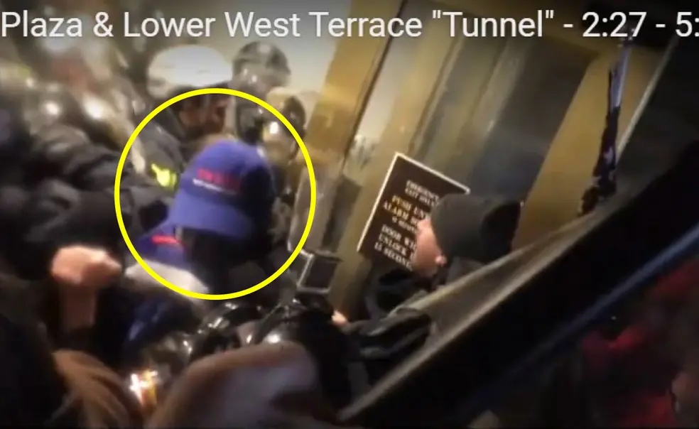 Giberson1.jpg Someone with a blue baseball cap is seen near doors; people in riot gear are in the background.