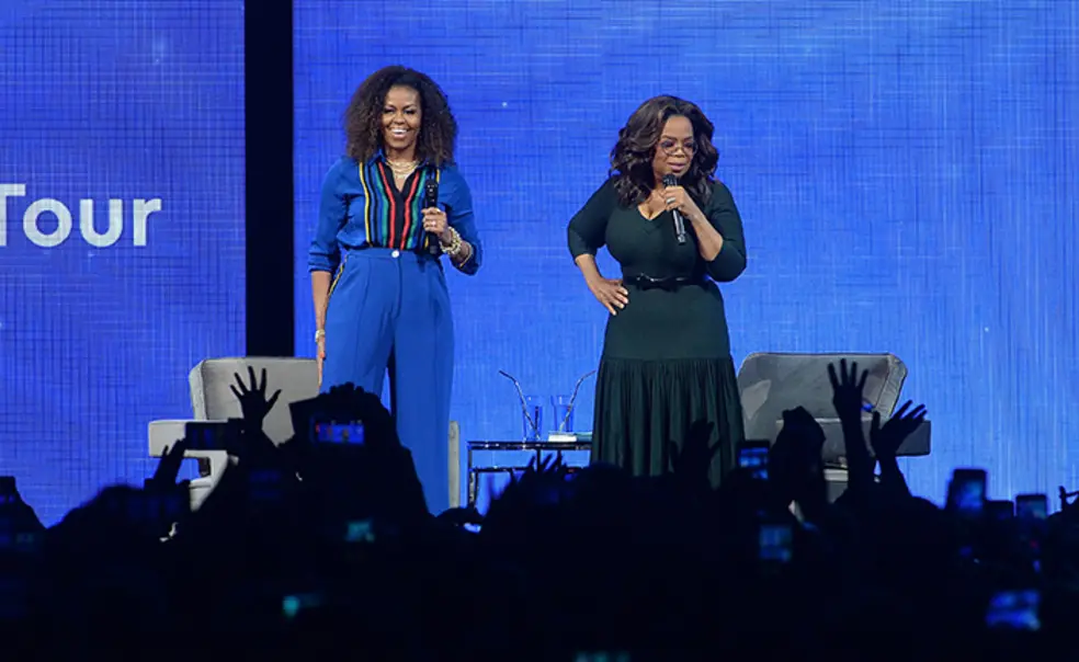 MichelleObamaOprah.jpg Michelle Obama and Oprah address an audience from a stage.