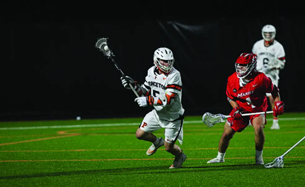 SPORTS_Alex Slusher.jpg Lacrosse player Alex Slusher, number 5, in white jersey and helmet, running around a defensive player