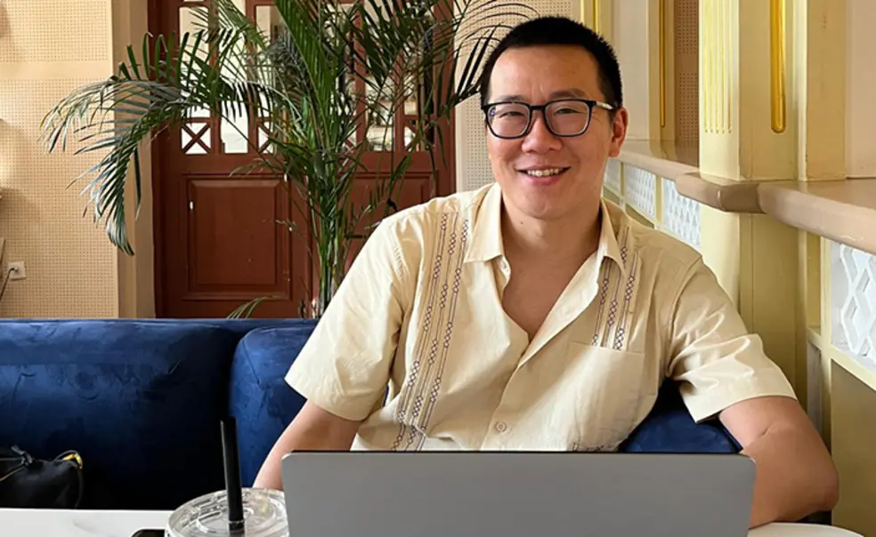 TOW_JonathanCheng.jpg Jonathan Cheng ’05 smiles up from his laptop computer.