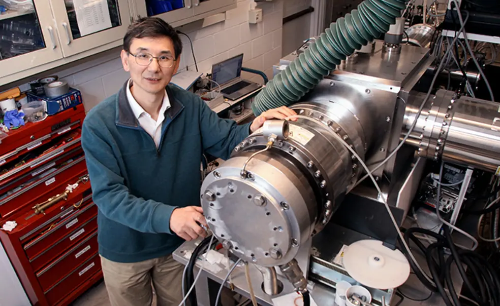 YiguangJu_cropped.jpg Yiguang Ju and some sort of machine with a red tool chest in the background.