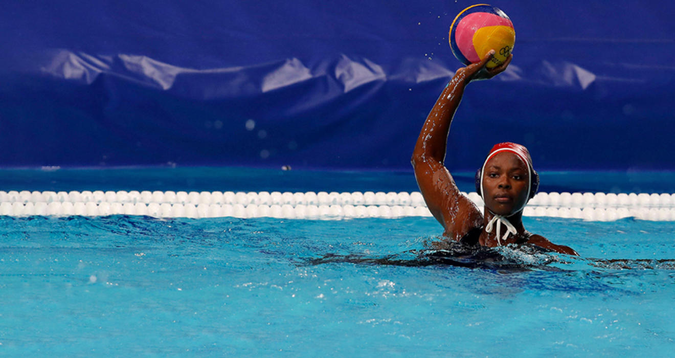 Water polo goalie Ashleigh Johnson ’17 palms the ball in her right hand and holds it over her head.