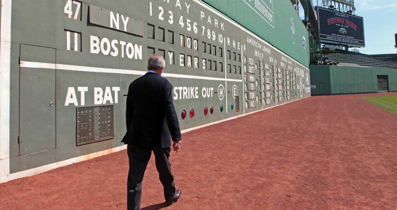 Larry Lucchino ’67 walking along Boston's Green Monster at Fenway Park