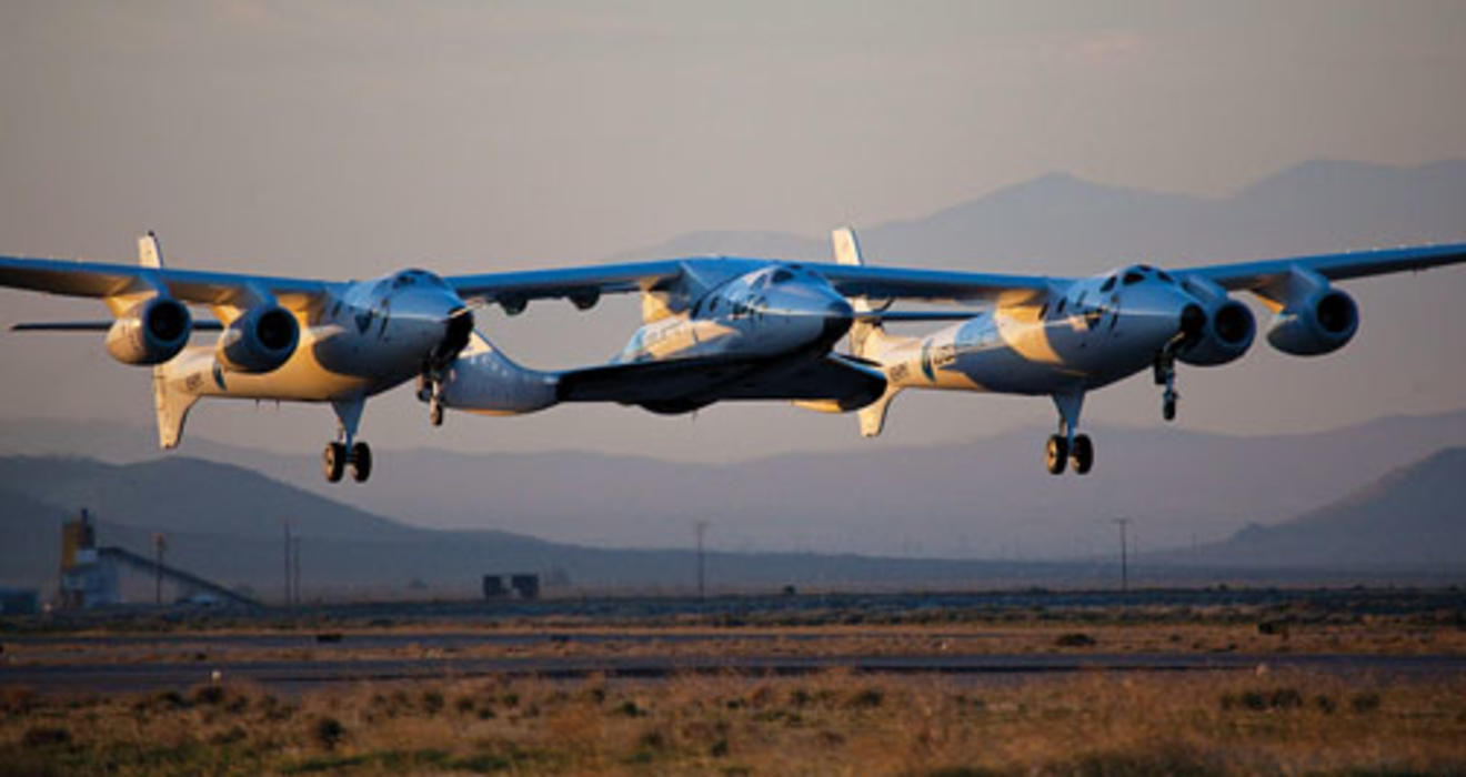 The WhiteKnight Two, known as the mother ship Eve, resembles a flying catamaran. Between the two “pontoons” is SpaceShip Two, christened the VSS Enterprise.