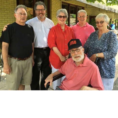 Photo of six people, five standing and one seated