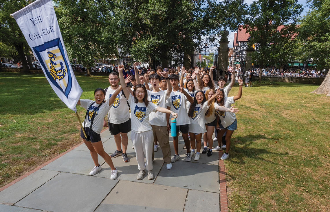 Students wearing Yeh College shirts cheer in front of Fitzrandolph gate.