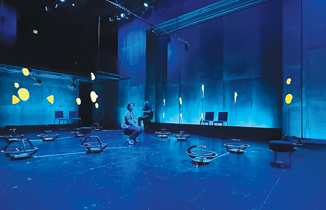 Robots scatter around a room lit with blue light.