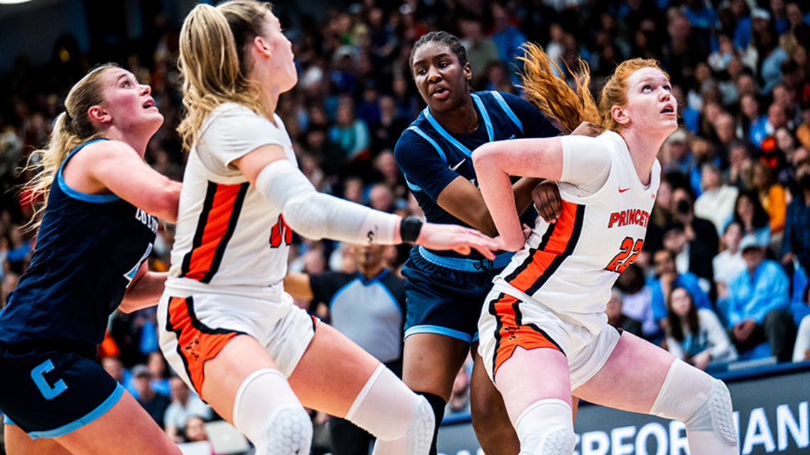 Four players vying for position to rebound the ball in a basketball game