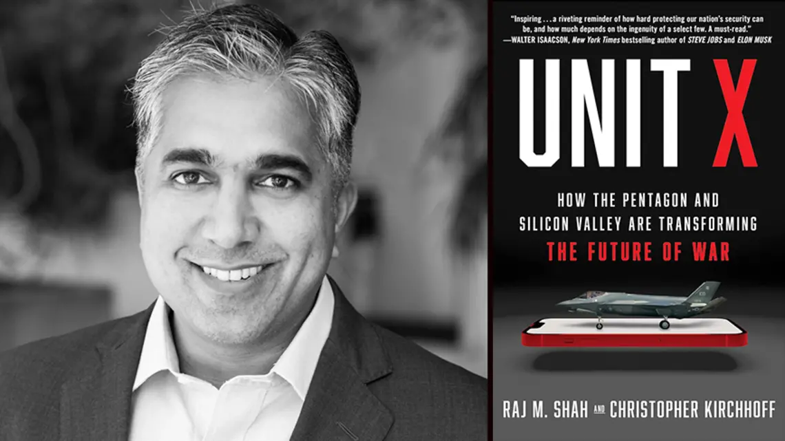 Raj Shah with the cover of his book, "Unit X," featuring an image of a fighter jet on top of a cell phone.