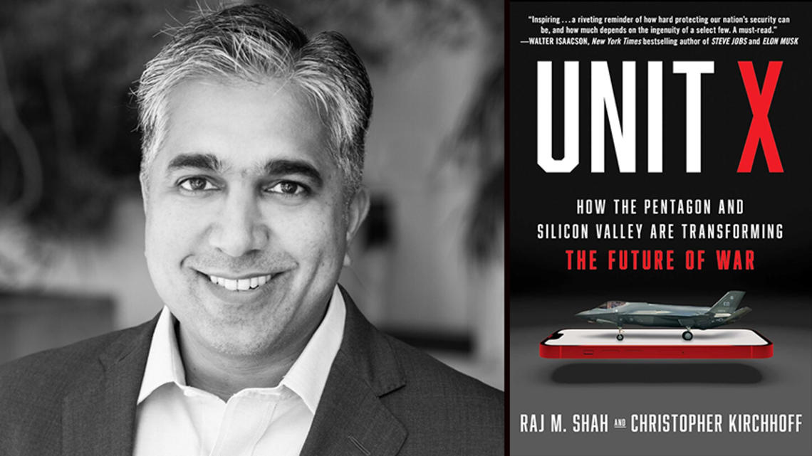 Raj Shah with the cover of his book, "Unit X," featuring an image of a fighter jet on top of a cell phone.