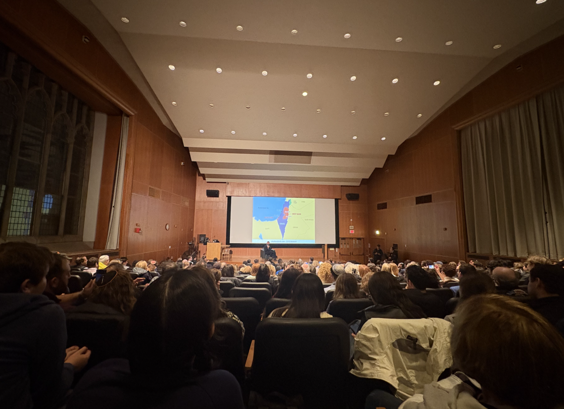 Mosab Hassan Yousef sits in front of a crowd in McCosh 10.