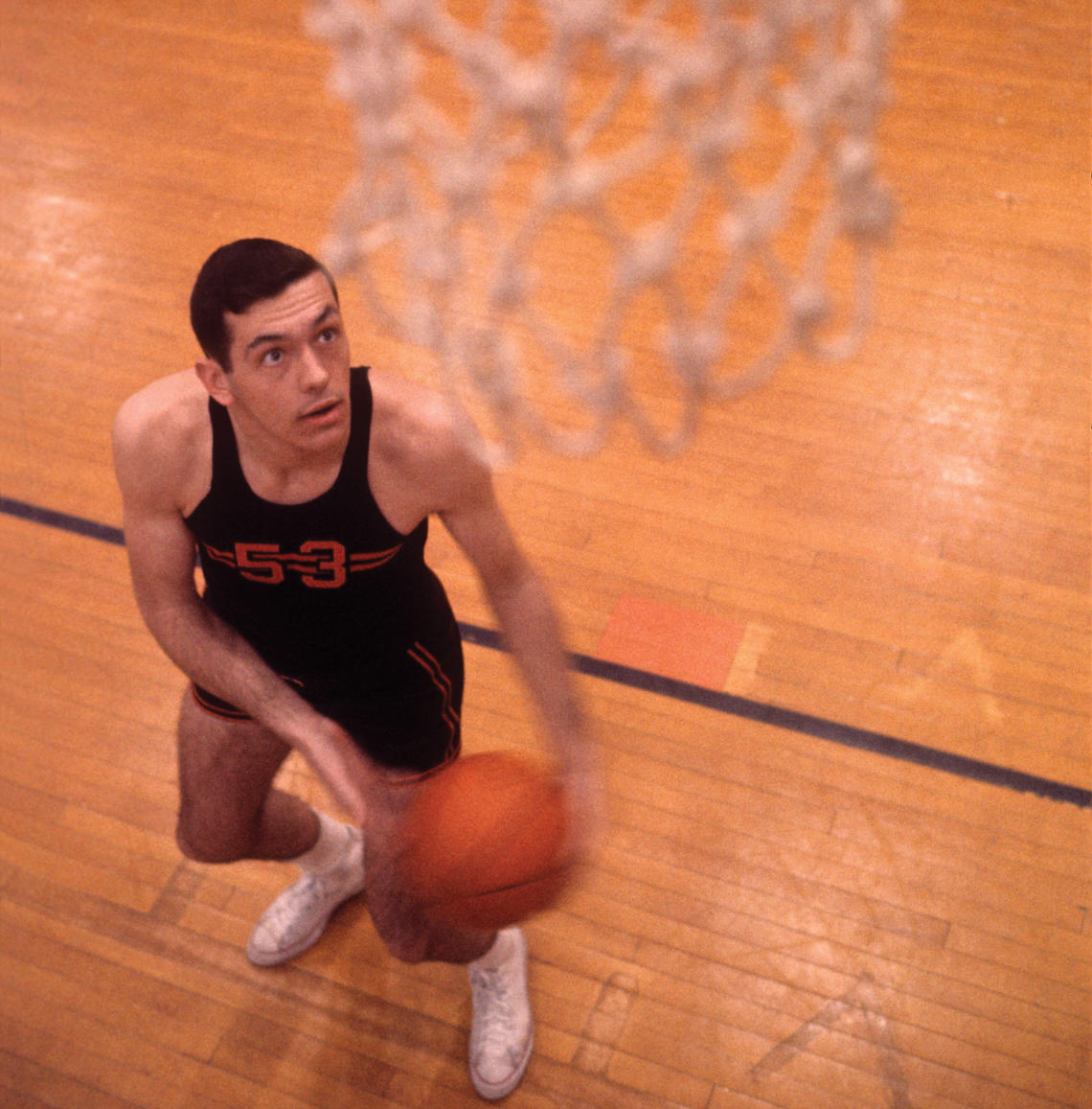 Bill Bradley ’65 looks up at the basketball net hanging in the foreground.