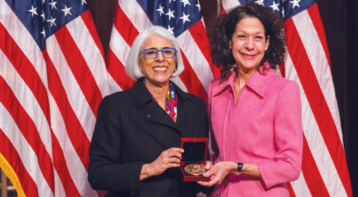 Professor Bonnie Bassler, right, receives  the National Medal of Science from  White House adviser Arati Prabhakar.