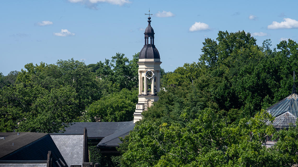 The cupola of Princeton's Nassau Hall peeks up from surrounding leafy trees.