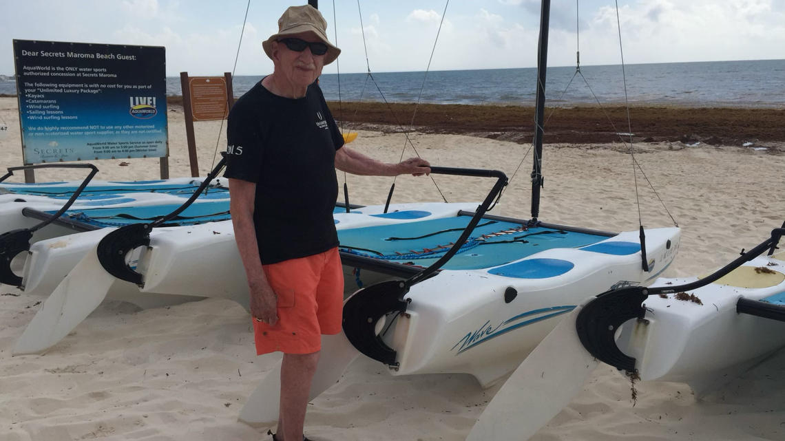 Donald Fletcher ’39 *51 stands in front of boats on a beach in Mexico.