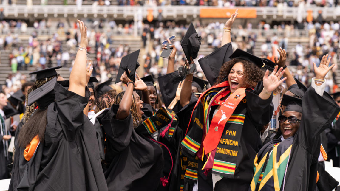 Group of students jumping and cheering at Commencement.
