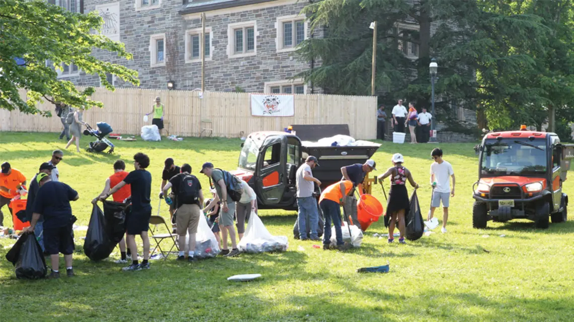 Groups of students and workers cleaning up trash after Reunions