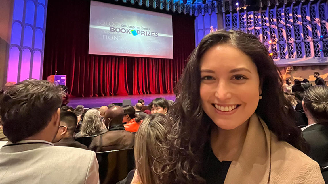 Allison Light ’18 take a selfie with the stage at the Los Angeles Times Book Prizes in the background.