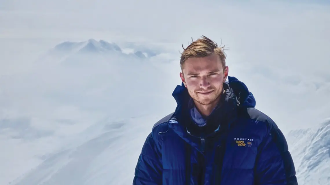 PRINCE_Ben Weissenbach 2.jpg Ben Weissenbach in a blue puffer jacket on top of a snow covered mountain