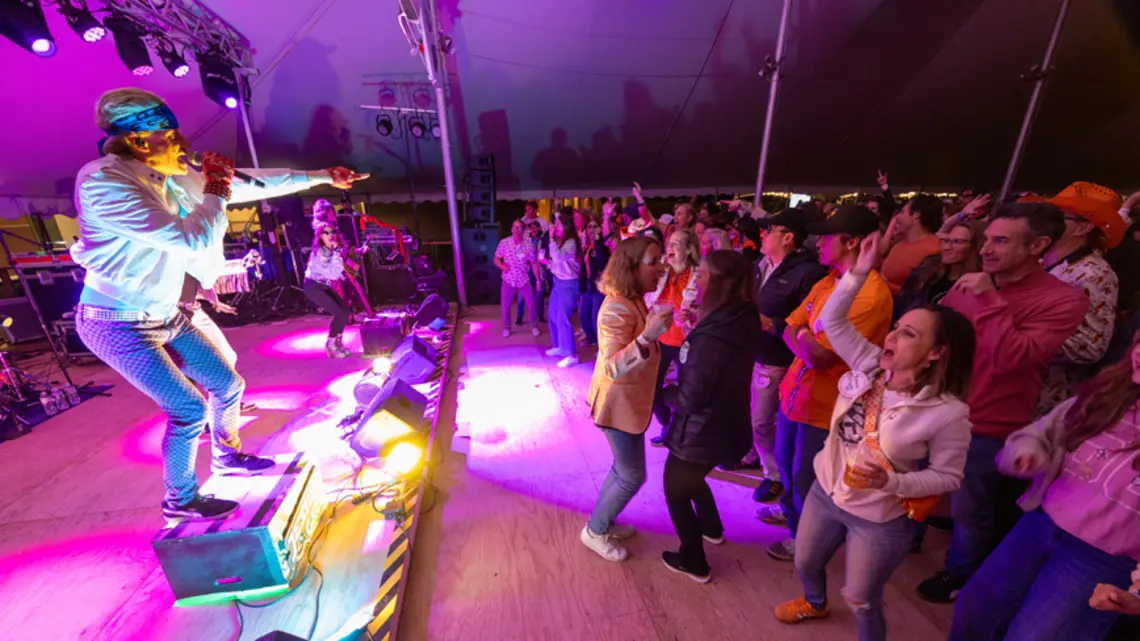 A band playing at the Class of 1995 tent during Reunions with people dancing