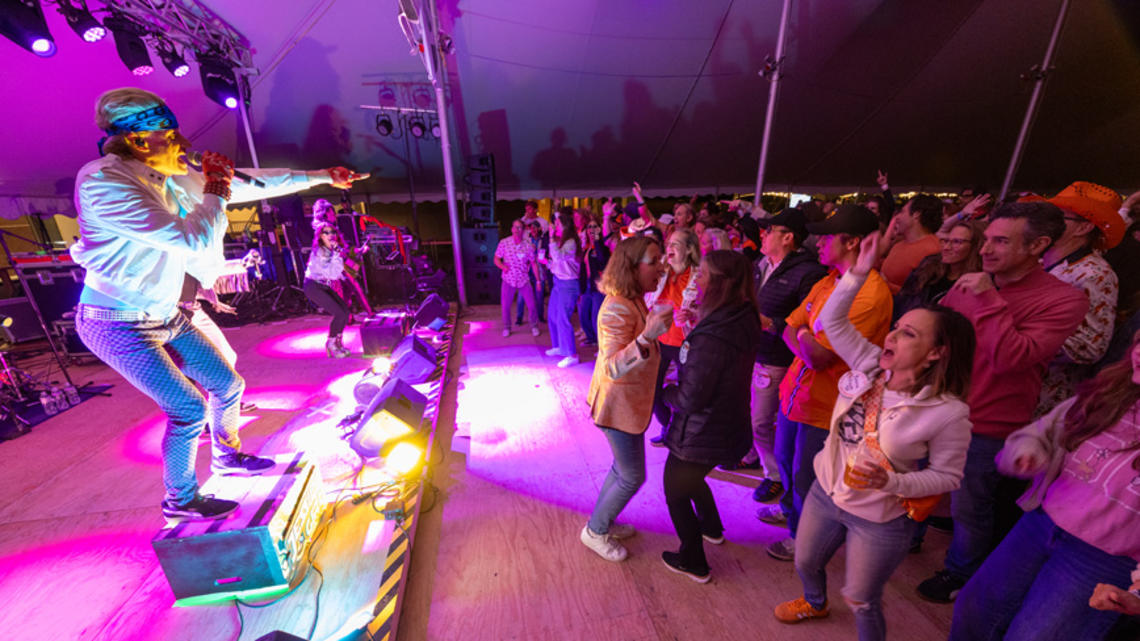 REUNIONS_Class of 1995 Rideshare.jpg A band playing at the Class of 1995 tent during Reunions with people dancing
