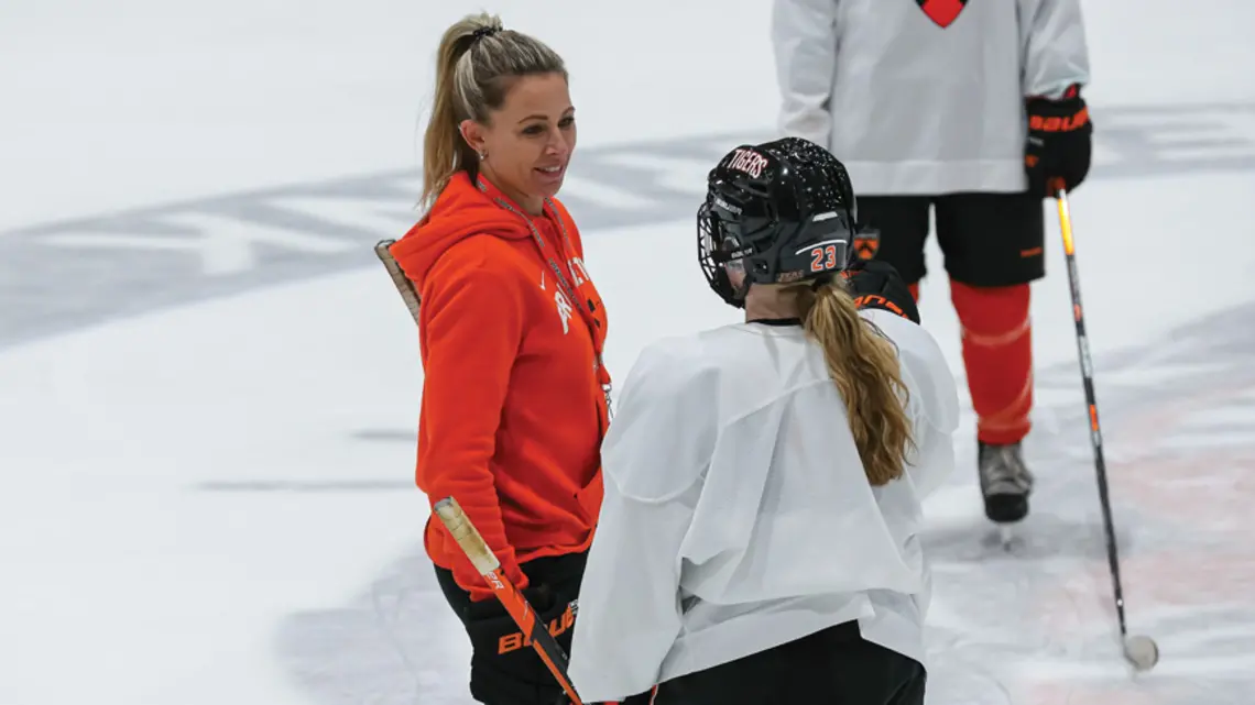 Cara Morey women’s ice hockey head coach talks to a plaey on the ice
